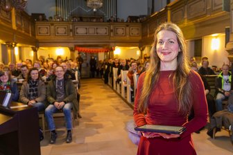 Popmusik, Glühwein und Gebet: Wie ein besonderer Gottesdienst die Ottendorfer Kirche bis auf den letzten Platz füllt - Pfarrerin Nina-Maria Mixtacki steht vor der vollbesetzten Kirche in Ottendorf und führt am Valentinstag durch einen Gottesdienst mit moderner Musik und neuen Formen.