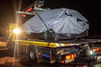 Das Porsche-Testfahrzeug wird nach einem schweren Unfall abgedeckt auf der Autobahn 81 bei Rottenburg (Baden-Württemberg) auf einen Abschleppwagen gehoben.