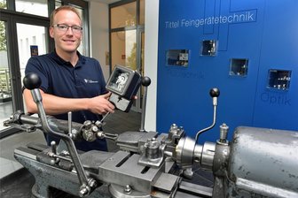 Präzision im Detail ist Firmenmaxime bei Tittel Feingerätetechnik in Frauenstein - Im Foyer der Firma zeigt Manuel Hüttel an einer alten, seinerzeit hochmodernen Maschine stehend, eine Schaltzeituhr, die in den DDR-Jahren für den gesamten Ostblock gebaut worden ist.