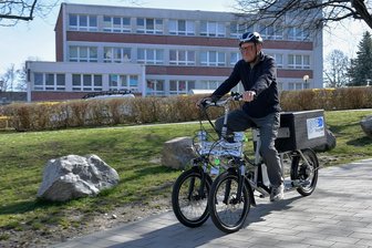Praxistest für Lastenfahrrad läuft in Freiberg - Zwei elektrische Lasten-Fahrräder können die Mieter der Städtischen Wohnungsgenossenschaft Freiberg (SWG), wie Klaus Hiemann (78/Foto), derzeit kostenfrei testen. Möglich ist dies durch das Projekt "Steig um", das von der TU Bergakademie, der TU Chemnitz, der Stadtverwaltung Freiberg und der SWG gemeinsam organisiert wird. Dafür wurde in einer Fahrradgarage in den Mineralienhöfen im Wohngebiet Friedeburg eine Lade-Station für die Lasten-Pedelecs aufgebaut. Das Verleihsystem funktioniert über eine App. Noch in diesem Jahr sollen in Freiberg weitere Lasten-Fahrrad-Stationen auf dem Campus und am Bahnhof entstehen. "Wir sind gespannt auf die Erfahrungsberichte zur Nutzbarkeit der Lastenfahrräder im Alltag", sagt Uni-Professorin und Projektkoordinatorin Jana Kertzscher. hh