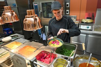Preiswertes Gericht und mehr Bio: Das gibt es ab jetzt in der Mensa der TU Chemnitz - Mensa-Küchenkraft Claudia Zielonka beim Anrichten des Aktionsgerichtes: Buttermilchcurry mit Hirse, Pink-Rettich und Koriander.