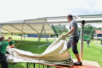 Premiere für originelles Event: Hutstadtfest beginnt am Freitag in Mulda - Das Hutstadtfest in Mulda beginnt am Freitagabend. Dafür wurde auf dem kleinen Sportplatz an der Bahnhofsstraße ein Festzelt aufgebaut. Marcel Schäfer (r.), der Chef des Dorfvereins, bereitet eine Dachplane vor.