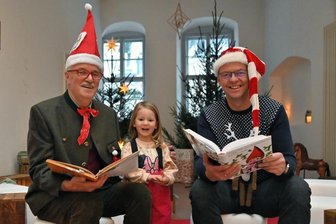 Zur Eröffnung der Märchenstube haben Reiner Uhlisch (li.) und Schneebergs Bürgermeister Ingo Seifert (re.) Kindern, wie der dreijährige Johanna Müller aus Schneeberg (Mitte) aus Grimms Märchen vorgelesen.