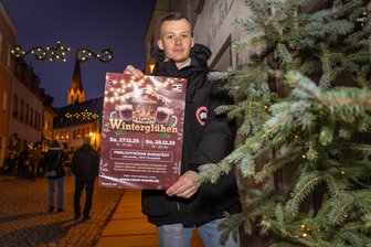Premiere in Burgstädt: Winterglühen mit Feuerkörben und Glühwein am Fuße des Taurasteinturms - Veranstalter Pascal Köhler macht im weihnachtlichen geschmückten Burgstädt Werbung für das 1. Winterglühen.