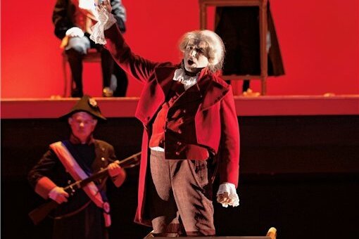 Premiere in Gera: Der Unverstand gelenkter Massen in einer vergessenen Oper - Traditionelle Kostüme vor blutrotem Hintergrund: Szene aus "Dantons Tod" im Theater Gera. 