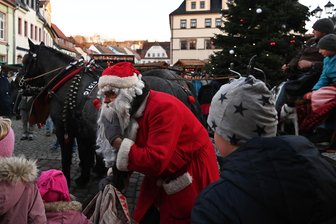 Premiere in Penig: Riesenstollen zum Weihnachtsmarkt verteilt - Auf dem Peniger Weihnachtsmarkt kam der Weihnachtsmann mit einer Pferdekutsche und war natürlich schnell von Kindern umringt.