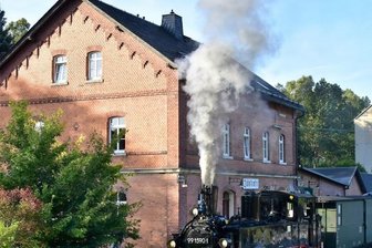 Preßnitztalbahn dampft in ein Jahr mit zwei Jubiläen - Anfang Oktober 2021 konnte erstmals wieder ein Zug vor dem Bahnhofsgebäude in Jöhstadt halten. Zuvor waren in aufwendiger Arbeit die Gleise neu verlegt worden. Hinten der Wohnblock, der im Zuge der Reaktivierung des Bahnhofs noch weichen soll. 
