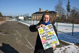Pump-Track-Anlage, Skaten, Tischtennis: Wie ein Jugendtreff in Lichtenau aus dem 3D-Drucker kommt - Jasmin Schauer betreut vom Verein „enter – Junge Kulturregion Chemnitz“ das Jugend-Projekt in Lichtenau. Sie steht vor der Fläche, die als Jugendtreff ausgebaut werden soll und zeigt ein Werbeplakat für die Aktion.