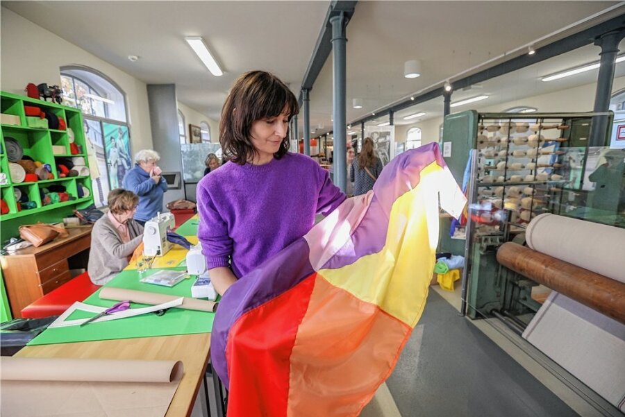 "Purple Path" zur Kulturhauptstadt Chemnitz: Am Kulturpfad sollen bunte Fahnen wehen - Passend zum "Purple Path" trägt Künstlerin und Workshopleiterin Anja Schwörer einen violetten Pullover. In den Händen hält sie eine Beispielflagge. 