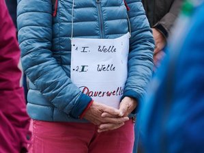 "Querdenken"-Demo in Leipzig soll auf die Neue Messe weichen - «1.Welle - 2.Welle - Dauerwelle» steht auf dem Plakat einer Demonstrantin bei einer Querdenken-Demo.