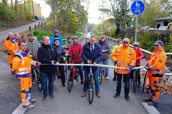 Radweg-Neubau ebnet Weg zu fahrradfreundlicher Stadt - Reichenbachs Oberbürgermeister Raphael Kürzinger (Mitte), Projektleiter Thomas Schmidt von der Baufirma HTR Reichenbach (rechts) sowie Planer Thomas Lantzsch beim Zerschneiden des symbolischen Bandes. Unter den ersten Radlern waren auch einige Stadträte.