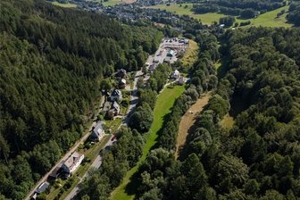 Radwegbau kann losgehen: Ehrenfriedersdorfer Firma übernimmt Millionenprojekt im Erzgebirge - Da entlang der Straße (links) kein Platz ist, wird der Radweg von Thum nach Herold (hinten) unterhalb der Deponie am Wertstoffhof entlang gelegt und quert zweimal den Jahnsbach, der hier von Bäumen verdeckt wird.