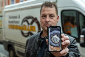 Räder an Verkaufswagen gelockert: Falkensteiner Bäcker setzt Belohnung auf Täter aus - Bäckermeister Marcel Weidenmüller zeigt auf dem Smartphone ein Bild vom Rad. Vermutlich hat jemand mutwillig die Schrauben an den Rädern des Verkaufswagens gelockert. Wer Hinweise zum Täter gibt, bekommt 500 Euro.