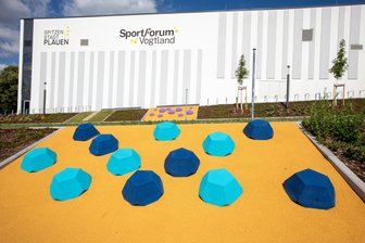 Rätsel um bunte Pickel vor neuer XXL-Turnhalle in Plauen: Was hat es mit den Elementen vor dem Sportforum Vogtland auf sich? - Passanten rätseln über die bunten Pickel vor dem Sportforum.