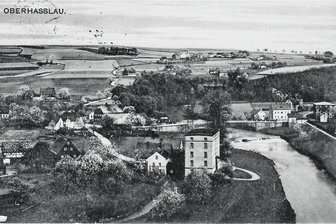 Rätsel um mysteriösen Straßeneinbruch ist gelöst: Ein verschütteter Abfluss der ehemaligen Fickert-Mühle ist die Ursache - Diese Postkarte aus dem Jahr 1916 zeigt die Fickert-Mühle in Oberhaßlau. Im unteren Teil des Bildes ist der Bach zu sehen, der das verbrauchte Wasser zurück zur Mulde leitete. Er wurde bei Straßenbauarbeiten zugeschüttet. 