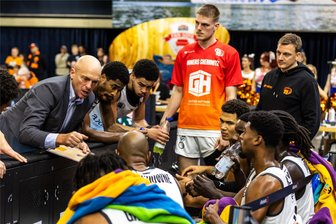 Rätselraten beim Spiel der Niners Chemnitz: Wer ist der unbekannte Mann in Teamkleidung auf der Spielerbank? - Auszeit bei den Niners Chemnitz: Nicht nur die Spieler lauschen gespannt, was Cheftrainer Rodrigo Pastore zu sagen hat. Rechts im Hintergrund hört auch ein Mann zu, den man dort zuvor nie gesehen hat.