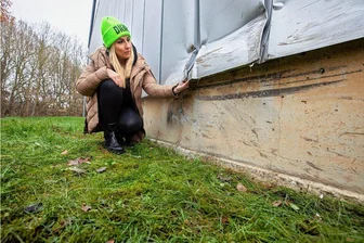 Rätselraten um mysteriösen Unfall am Plauener Sportpark - Sportpark-Chefin Annett Lachmann begutachtet den Schaden an der Fassade ihres Gebäudes. Ein Unbekannter hatte die Aluhaut auf einer Länge von mehreren Metern beschädigt.