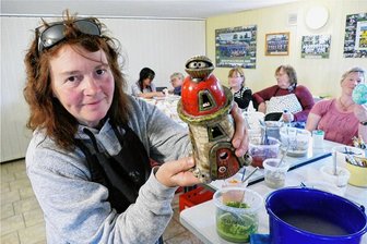 Rakuritäten: Tournee besonderer Art macht in Grünhainichen Station - Während im Hintergrund einige Kursteilnehmerinnen noch mit dem Anmalen beschäftigt sind, präsentiert Regina Chinow eins ihrer fertigen Werke - natürlich mit Augen. Erst nach gründlichem Waschen, dem letzten Arbeitsschritt, kommen dabei Farbe und Glanz voll zur Geltung. 