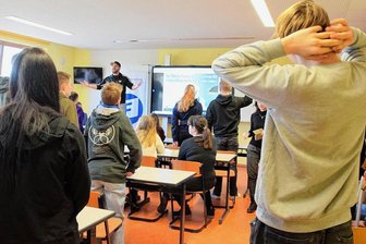 Rapper Ben Salomo hält in Neumark zwei bewegende Unterrichtsstunden - Unterricht mal anders: Wer die von Rapper Ben Salomo (hinten stehend mit Basecap) zitierten Gerüchte oder Vorurteile schon einmal gehört hatte, durfte aufstehen, bei weiteren die Hände heben und auf den Stuhl steigen. Am Ende saßen nur noch wenige.