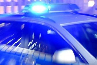            Ein Streifenwagen der Polizei steht mit eingeschaltetem Blaulicht auf der Straße.