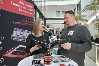 „Raus aus der Automobilindustrie“: Wie VW-Arbeiter nach einer neuen beruflichen Perspektive suchen - Bei der Fachkräftebörse im Zwickauer Rathaus mischen sich viele VW-Arbeiter unter die Besucher. Auch Patrick Leistner sucht nach einer beruflichen Perspektive und lässt sich am Stand der Lengenfelder Firma Kobra von Julia Wild beraten.