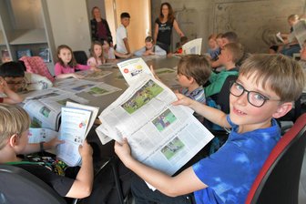 Redaktionsgeheimnisse gelüftet: Schüler blicken hinter die Kulissen der „Freien Presse“ Freiberg - Die Klasse 3a der Carl-Böhme-Grundschule Freiberg zu Besuch in der Lokalredaktion der „Freien Presse“ am Kirchgäßchen. Im Bild: Emil Kriegel, der ein Foto seiner Schwester Rosa auf einer Sportseite entdeckt hat.