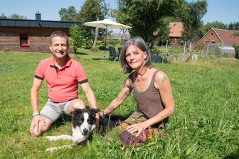 Refugium für Gesundheit: Paar schafft sich im Vogtland besondere Praxis - Jana Bina und ihr Mann Matthias Bina zusammen mit ihren Hund Mozart auf ihrem Grundstück in Willitzgrün.