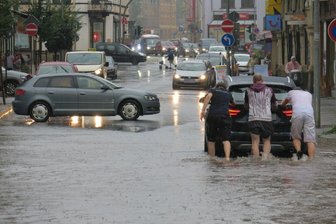 Regen überflutet Bahnhofstraße in Aue - Nach dem Unwetter steckte ein Fahrzeug in den Fluten auf der Auer Bahnhofstraße fest. Fußgänger schoben das Auto aus dem Wasser.