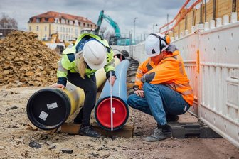 Die Planerin der SachsenEnergie und ein Bauleiter kontrollieren einen Abschnitt des Schutzrohres für die neue Trinkwasserleitung in Dresden Cotta