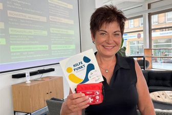 Reichenbach: Aktion Hilfepunkt startet mit acht Partnern - Ina Meisel vom Kommunalen Präventionsrat der Stadt mit dem Hilfepunkt-Aufkleber und einem Verbandsset.