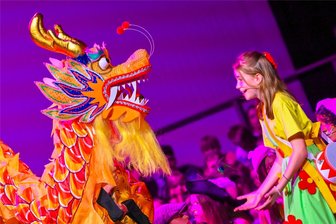 Reichenbach: Etwa 200 Akteure erleben mit Kindermusical „Felicitas Kunterbunt“ dreimal ein ausverkauftes Neuberinhaus - Julia Dommaschk begibt sich als Felicitas Kunterbunt auf die Suche nach dem Schlüssel für die Spielzeugtruhe. Im Bild ist sie mit dem Drachen zu sehen.