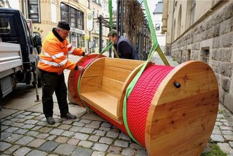 Reichenbach: Garnrollenbänke kehren zurück - Mitarbeiter des Bauhofs beim Aufbau der Garnrollenbänke im April 2022 in der Zwickauer Straße.
