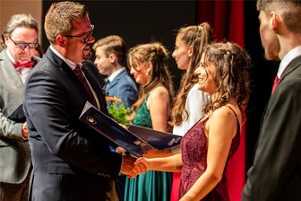 Reichenbach: Schulleiter ist stolz auf den Abi-Jahrgang 2024 - Schulleiter Christian Reinsch gratuliert Kathleen Gambke bei der feierlichen Zeugnisübergabe im Neuberinhaus zu ihrem 1,0-Abitur.