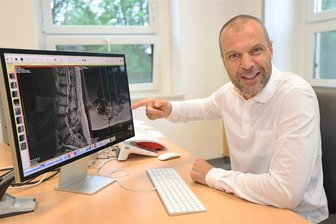 Reichenbach: Wirbelsäulen-Spezialist eröffnet Praxis in der ehemaligen Klinik - Neurochirurg André Roth wertet in seiner Praxis in Reichenbach Kernspinaufnahmen einer Wirbelsäule aus: