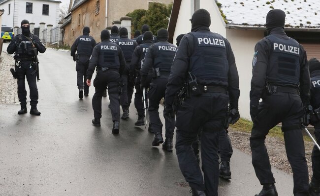 Thüringen: Einsatzkräfte der Polizei laufen zum Jagdschloss, während der Durchsuchung durch die Polizei.