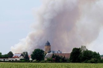 Rauch eines Waldbrandes steigt über dem Dorf Lichtensee (Landkreis Meißen) auf. Seit Donnerstag brennt es in der Gohrischheide.