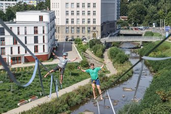 Rekordjäger auf waghalsigem Balance-Akt über die Chemnitz - Jens Decke (links) und Ruben Langer balancieren am Donnerstag auf einer Slackline zwischen Weltecho und der Deutschen Bank.
