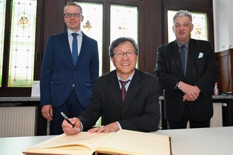 Repräsentant Taiwans zu Antrittsbesuch bei Landrat Anton - Prof. Dr. Jhy-Wey Shieh (Mitte) beim Eintragen ins Ehrenbuch der Stadt Aue-Bad Schlema im Juli 2021. Im Hintergrund stehen der ehemalige CDU-Bundestagsabgeordnete Alexander Krauß (l.) und der ehemalige Oberbürgermeister von Aue-Bad Schlema, Heinrich Kohl (CDU).