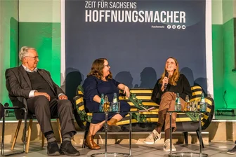 Ricarda Lang im Erzgebirge: Wofür ihr ein CDU-Mann applaudierte - „Weites Herz, begrenzte Möglichkeiten“: Grünen-Chefin Ricarda Lang (Mitte), Integrationshelferin Claudia Nikol und der Ausländerbeauftragte Geert Mackenroth auf dem Sachsensofa in Glashütte.
