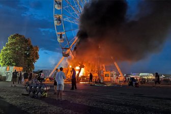 Riesenrad-Feuer auf dem Highfield: Brand-Opfer müssen operiert werden - Großpösna am Samstagabend: Besucher des Highfield-Festivals blicken auf das brennende Fahrgeschäft.