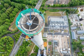Riesenspinne knabbert Esse in Chemnitz ab: So lange dauern die Abrissarbeiten - Wegen ihrer Lage mitten in der Stadt kann die 225 Meter hohe Esse in Altchemnitz nicht gesprengt werden. Stattdessen wird sie Stück für Stück abgebrochen, ein Fangnetz schützt die Baustelle.