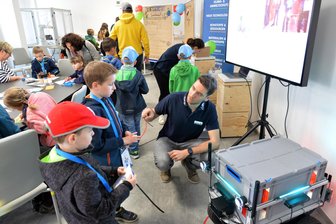 Roboter „Rosee“ begeistert junge Forscher im KidsLab der TU Freiberg - KidsLab der TU Bergakademie Freiberg: Norman Seyffer, wissenschaftlicher Mitarbeiter im Bereich Robotik an der TU zeigt Kinder „Rosee“, einen hochautomatisierten Roboter, der ältere Menschen unterstützen soll.