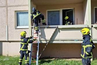 Rochlitz: Feuerwehr rückt zu Wohnblock aus - Die Feuerwehrleute stiegen unter Atemschutz mit einer Leiter auf den Balkon.