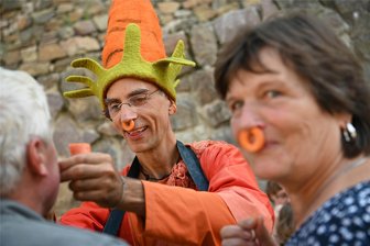 Rochsburg: Festival öffnet das Tor zur Sagenwelt – mit Sorbet, Koffer und Bienen - Beim Mittelsächsischen Sagenfestival auf der Rochsburg fertigte Pan Panazeh, der aus dem Fläming südlich von Berlin kommt, allerhand aus Möhren – zum Beispiel Nasenringe oder Pfeifen.