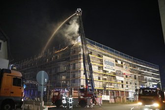 Rohbau eines Wohn- und Geschäftshauses brennt - 