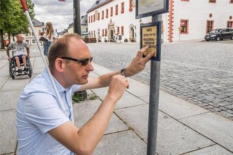 Rollstuhlfahrer und Blinder machen den Test: So barrierefrei ist Marienberg - Sören Goldberg ist blind. Er hofft bei der Suche nach der richtigen Bushaltestelle auf telefonische Hilfe. Auch Rollstuhlfahrer Maximilian Eichinger ist beim Test dabei (im Hintergrund).