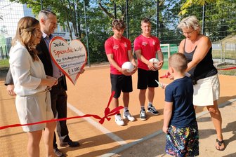 Ronaldo-Fan Harry (5) darf das Band durchschneiden: Neuer Bolzplatz in Zwickauer Kita eingeweiht - Harry List hat das Band durchgeschnitten, flankiert von Kita-Leiterin Kati Lissy, Randolf Friesen, Yannic Voigt (beide FSV Zwickau), Lutz Hering und Nadja Münzner (beide DRH-Stiftung Kinderhilfe; von rechts).
