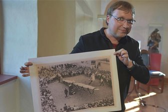 Rotes Oelsnitz, braunes Plauen: Ausstellung widmet sich den wilden Zwanzigern im Vogtland - Christian Espig vom Historischen Archiv des Vogtlandkreises mit einem Foto, das auf dem Marktplatz von Oelsnitz entstand und für viel Aufsehen sorgte. Es war eine Werbeaktion des Jagdfliegers aus dem 1. Weltkrieg Hermann Köhl, der mit einem Flugzeug 1927 den Atlantik überqueren wollte.