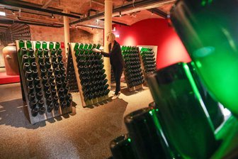 Rotkäppchen-Mumm bringt neues Mixgetränk in die Läden - Eine Frau rüttelt zum Test Sektflaschen in der Erlebniswelt des Sektherstellers Rotkäppchen-Mumm in Freyburg (Unstrut).