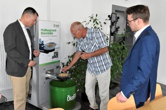 Rotschau: Pelletheizungen für den ganzen Osten - FDP-Bundestagsabgeordneter Torsten Herbst (l.) und FDP-Kreisvorsitzender Jeremy Ziron (r.) lassen sich von Horst Reinsch vom Ökofen Vertriebscenter Ost die Wirkungsweise eines Multisegment-Brenntellers erläutern.